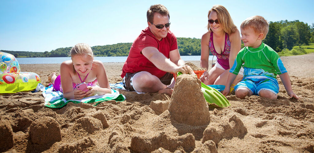 Family playing in the sand at the beach