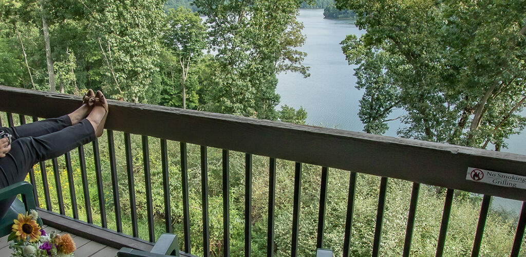 A woman sits on her lodge room balcony at Salt Fork Lodge