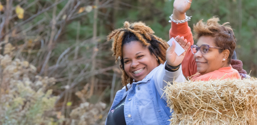 people waving on hay bales