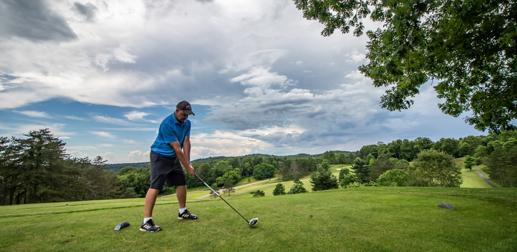 Golf member teeing off