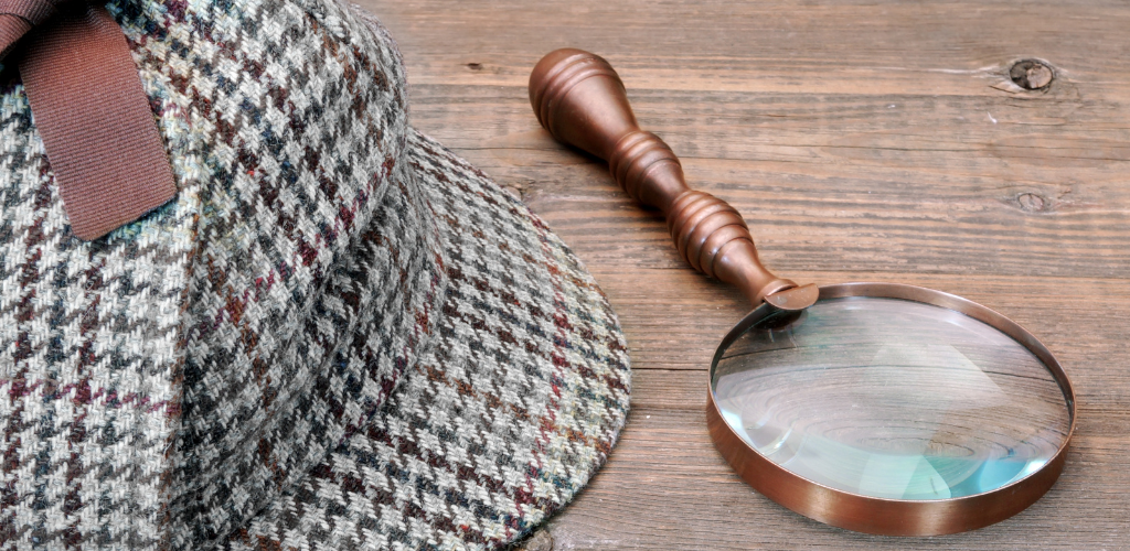 Detective Cap and Magnifying Glass laying on table